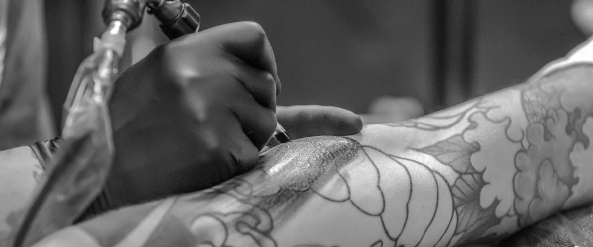 pexels-photo-955938-955938 Artistic black and white photo capturing the detailed process of tattooing an arm.
